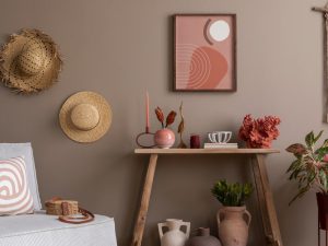 Imagen representativa del artículo cómo decorar un living. Se muestra un living con un sillón, una mesa, sombreros colgados en la pared y un cuadro.